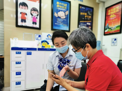 建行成都第六支行，大堂經(jīng)理為客戶介紹手機銀行&ldquo;大字&rdquo;模式